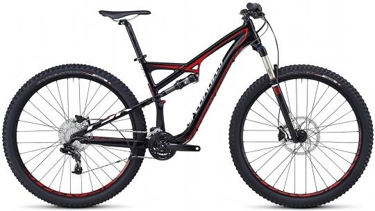 Specialized Camber 29: Mountain bike featuring a sleek black and red design, full suspension, wide tires, and disc brakes. Designed for off-road trails and rugged terrain, showcasing advanced shock absorption and gear components.
