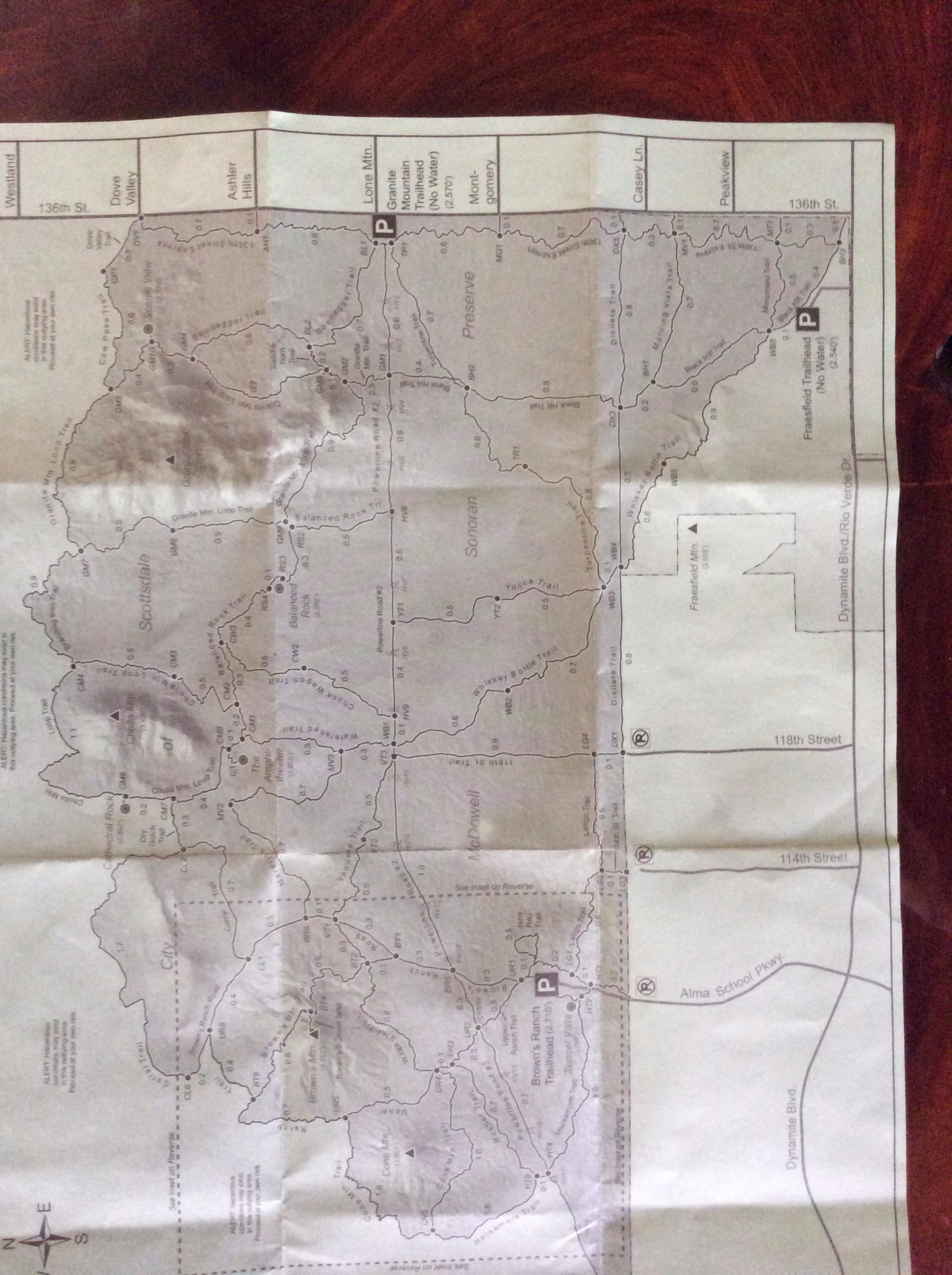 Map of a mountainous area featuring various trails, roads, and points of interest, with marked parking locations and a north orientation indicator. The map is printed in black and white, highlighting topographical features. Brown's Ranch to Granite Mountain mountain bike trail.