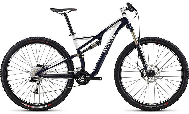 Specialized Stumpjumper FSR Comp 29: Alt text: A mountain bike featuring a lightweight frame in navy blue and white colors, with wide tires and a front suspension fork, positioned on a white background.