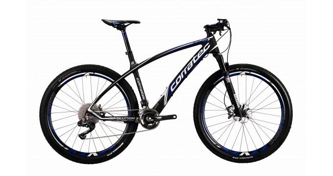 Motobecane NightTrain Bullet: A black and blue mountain bike with a sleek design, featuring a lightweight frame, front suspension, and knobby tires suitable for off-road trails. The bike has detailed gear components and a modern aesthetic, ideal for cycling enthusiasts.