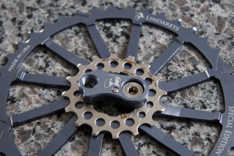 A close-up view of a specialized bicycle component displayed on a textured granite surface. The image features a circular bicycle cog with a silver and gray metallic finish, prominently marked with "Lindarets" and "Special Edition." The cog has several cutouts and an attachment point at the center, highlighting its design and craftsmanship.