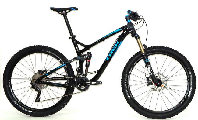 Trek Trek Remedy 8 27.5: A black and blue mountain bike with a suspension frame, wide tires, and disc brakes, positioned on a white background.