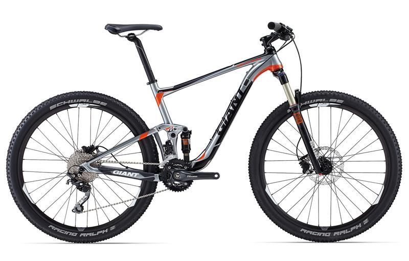 Giant Anthem 27.5 3: A modern mountain bike with a lightweight aluminum frame, featuring a silver and orange color scheme. It has large 29-inch tires, a front suspension fork, and a gear system designed for off-road performance. The bike displays branding from the manufacturer "Giant" and includes high-performance components.