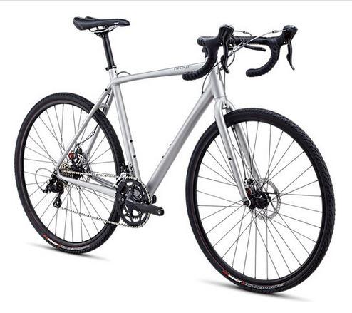 Specialized Tricross sport disk: A silver bicycle with a lightweight frame, drop handlebars, and disc brakes. The bike is designed for road or gravel cycling, featuring thin tires suitable for various terrains.