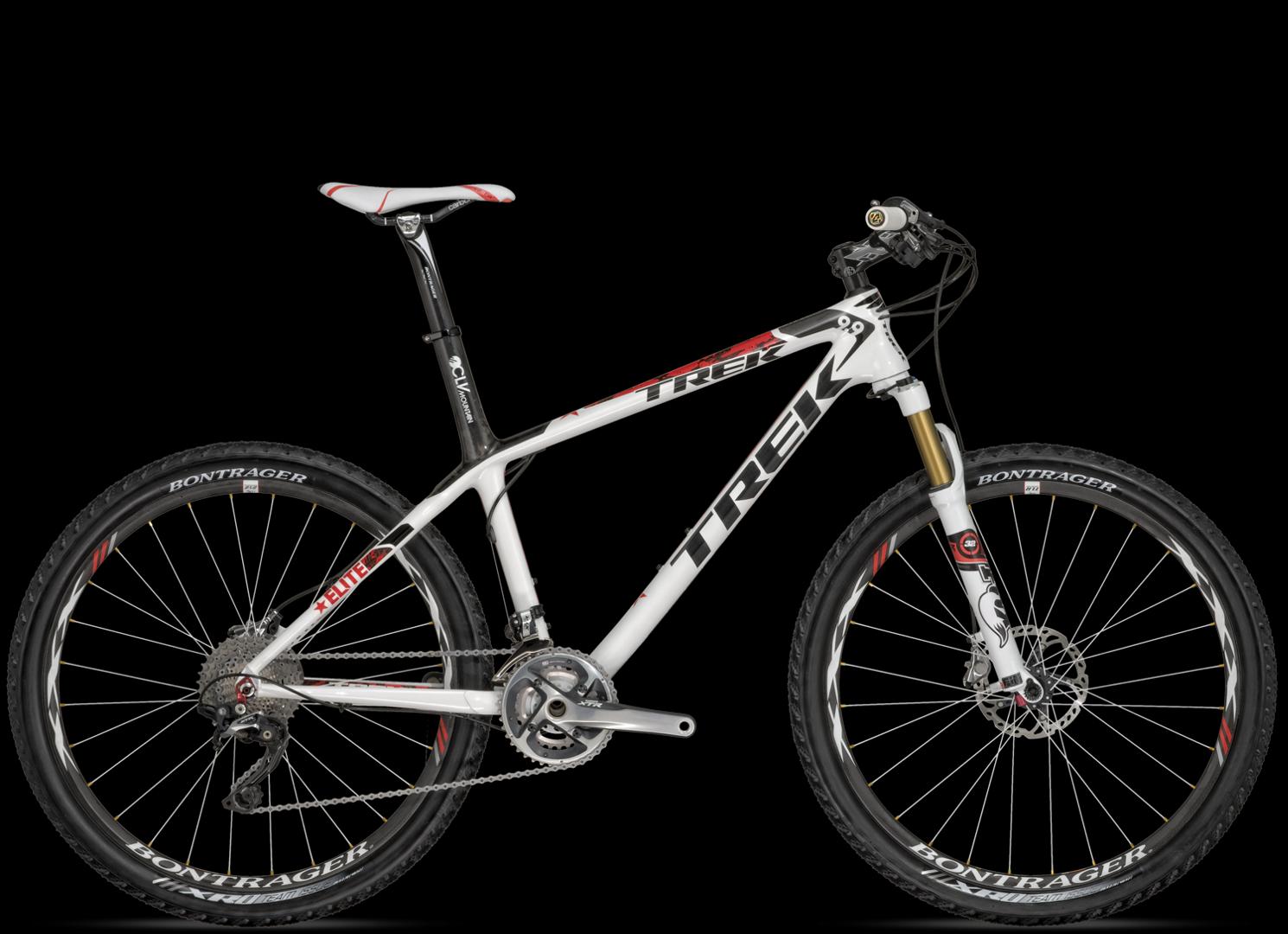 Trek Trek Elite 9.9: A white and red mountain bike with distinct brand markings, featuring a sleek frame, durable tires, and a front suspension fork. The bike is displayed against a black background, highlighting its design and components.
