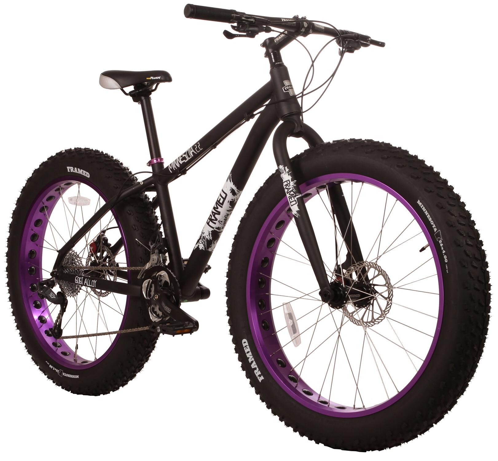 Framed Minnesota 2.0: A black fat tire bike with purple rims, featuring a sturdy frame and wide, textured tires designed for off-road riding. The bicycle is shown from a slight angle, highlighting its robust construction and unique color combination.