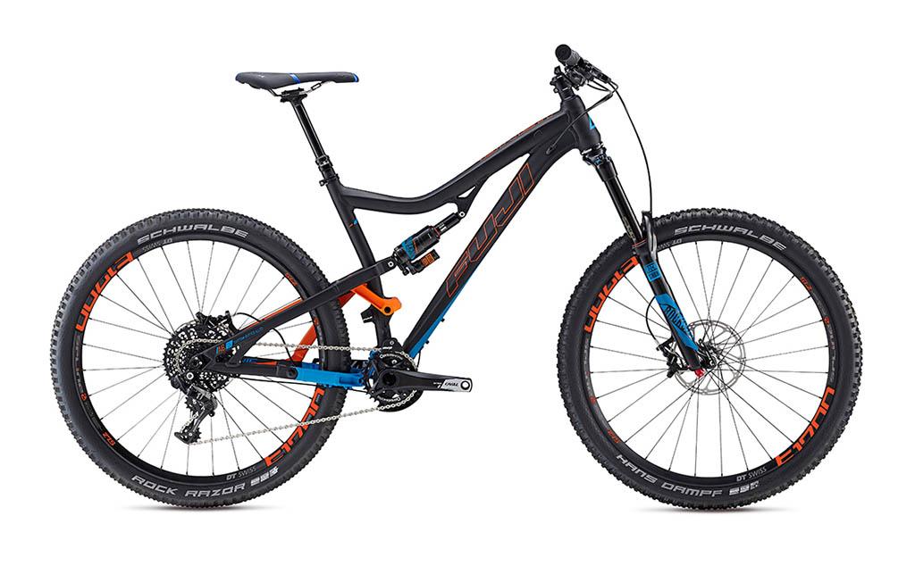 Fuji Auric: A modern mountain bike with a sleek black frame accented by blue and orange details. It features wide tires, a full suspension system, and high-performance components designed for rugged terrain. The bike is shown from the side, highlighting its durable design and advanced engineering.