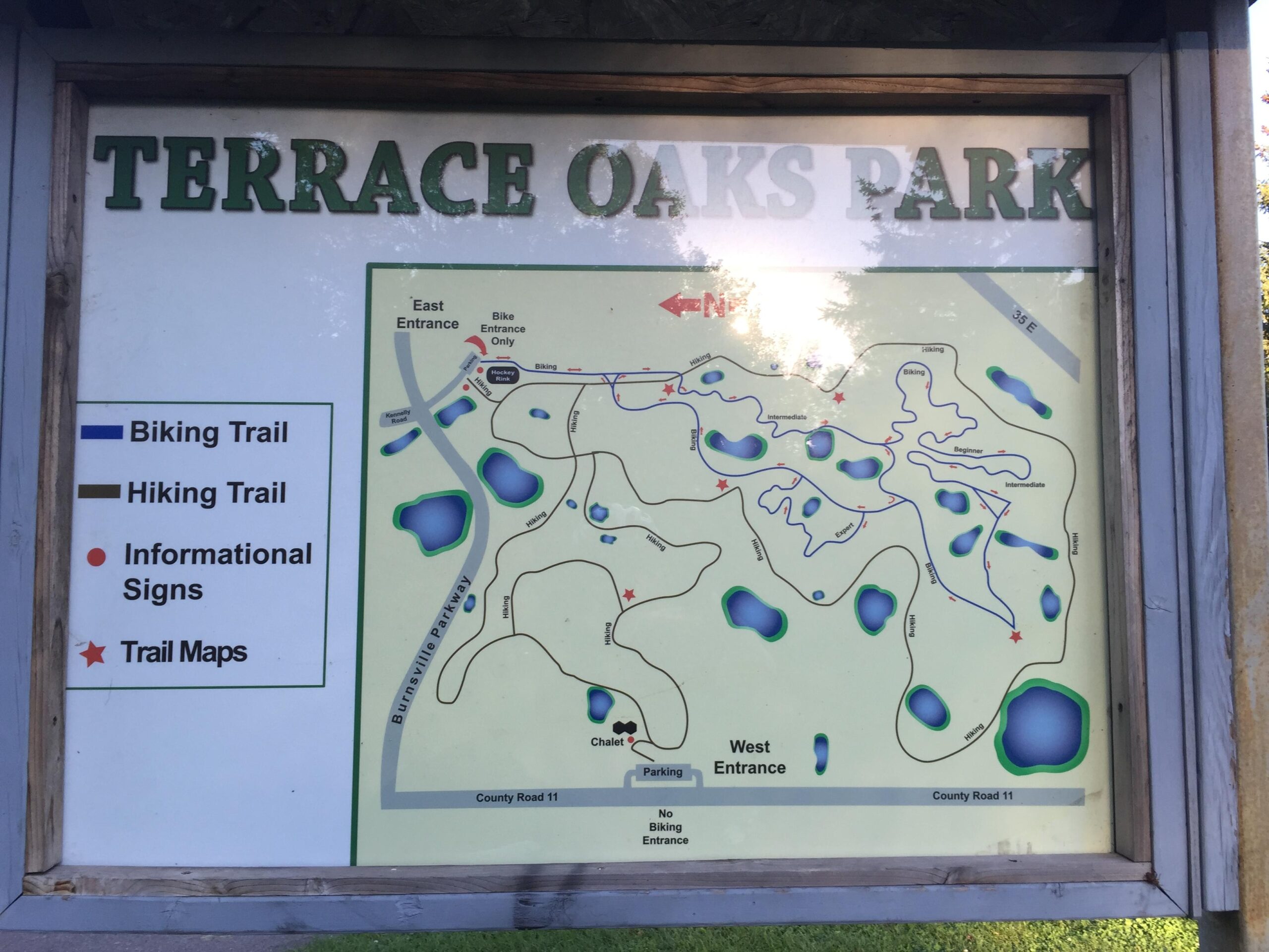 Map of Terrace Oaks Park, featuring designated biking and hiking trails, entrance locations, and informational sign placements. The map includes sections labeled for beginner and intermediate biking paths, along with notable landmarks such as parking and trail maps. Terrace Oaks East Park mountain bike trail.