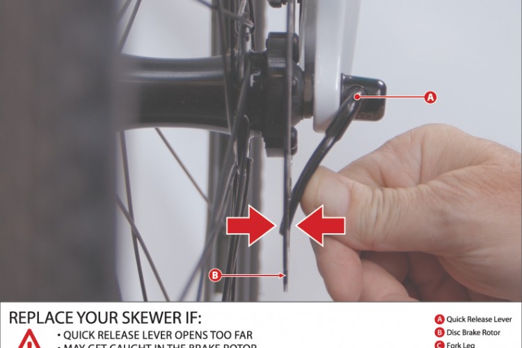 Close-up image of a hand adjusting the quick release lever on a bicycle wheel assembly. Labels identify components such as the quick release lever (A), disc brake rotor (B), fork leg (C), and brake caliper (D). A warning message highlights the need to replace the skewer if the quick release lever opens too far, as it may catch on the brake rotor and cause the front wheel to lock up suddenly.