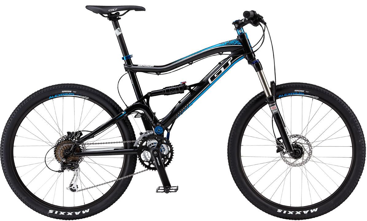 GT Sensor: A black and blue mountain bike with dual suspension, featuring wide tires, disc brakes, and a sleek, modern design. The bike is positioned against a plain background, showcasing its frame and components clearly.