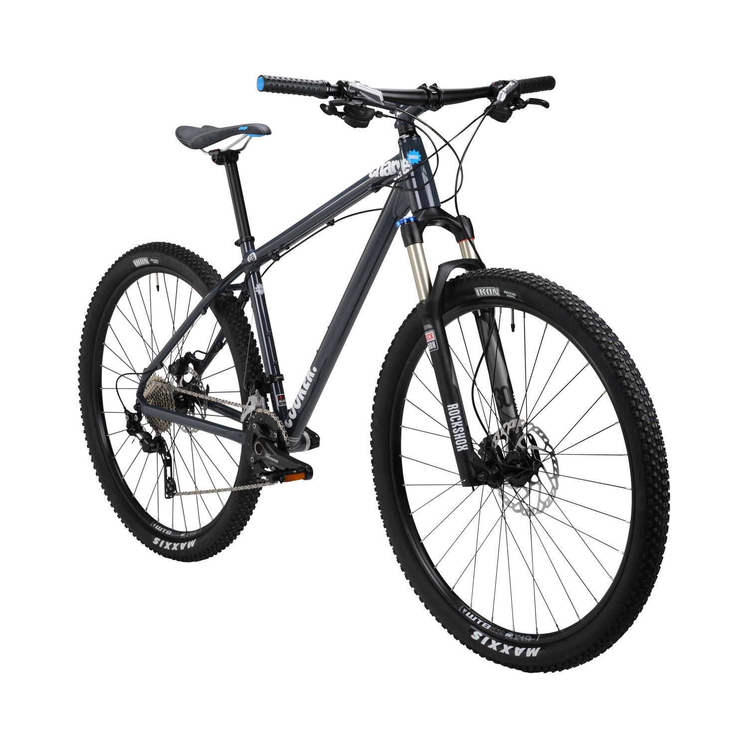 Charge Charge Cooker 29er Performance Exclusive: Alt text: A modern mountain bike with a gray frame, front suspension, and knobby tires, positioned at an angle to showcase its components including the seat, handlebars, and chain.
