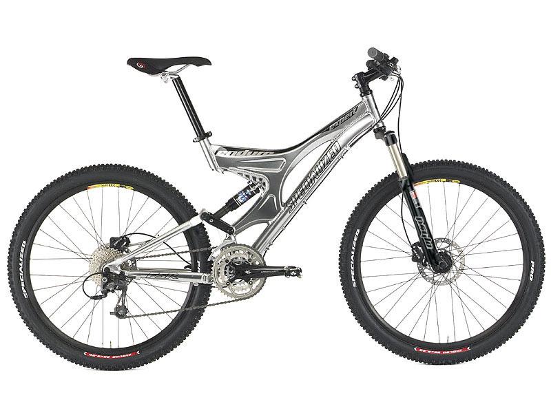 Specialized Enduro: A silver and black mountain bike with large wheels, a suspension system, and a modern frame design. The bike features a prominent shock absorber at the front, wide tires suitable for off-road terrain, and a gear set on the rear wheel. The seat is adjustable, and the handlebars are designed for enhanced grip and control.