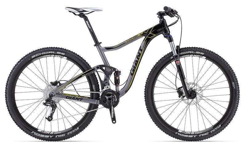 Giant Trance: Image of a mountain bike featuring a sleek black and gray frame with yellow accents. The bike is equipped with wide tires, front suspension, and a gear system, designed for off-road terrain. The handlebars have ergonomic grips, and the bike stands upright on a plain white background.