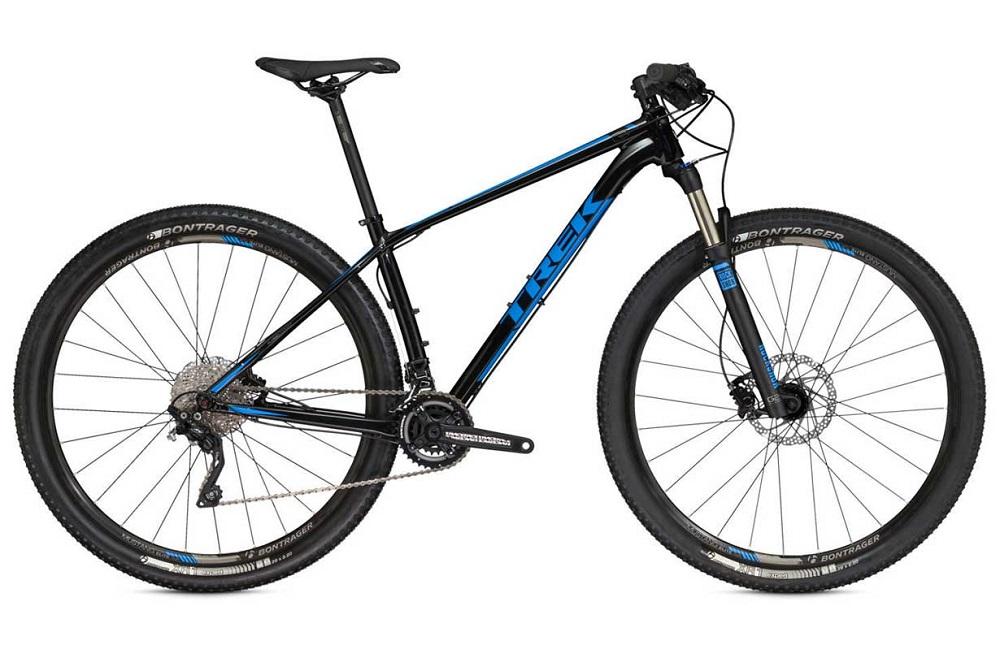Trek Superfly 5: A black and blue mountain bike with a lightweight frame, featuring wide tires and disc brakes, positioned against a plain background. The bike showcases a front suspension fork and a Shimano drivetrain system.