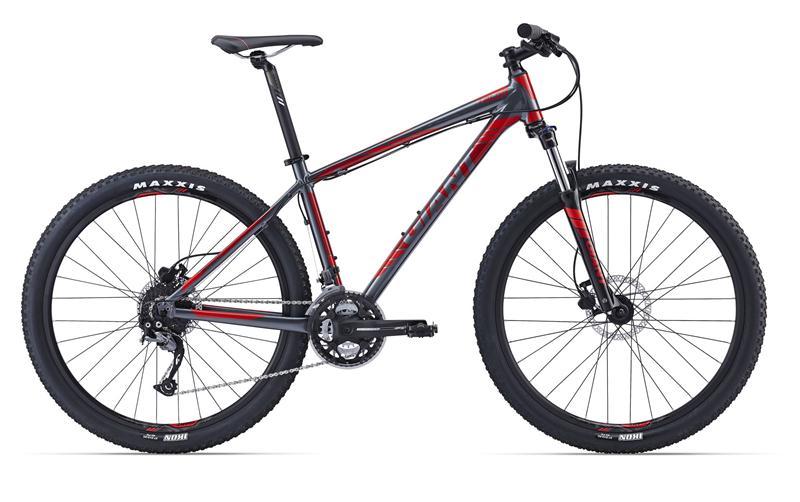 Giant Talon 27.5 3: A modern mountain bike featuring a sleek gray and red frame, disc brakes, and rugged tires designed for off-road cycling. The bike is shown from the side, highlighting its sturdy construction and gear system.