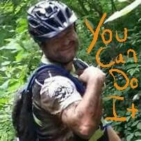 A person wearing a helmet and cycling gear is smiling and posing in a lush green forest setting. There is handwritten text overlay that says "You Can Do It." DuPont State Forest mountain bike trail.