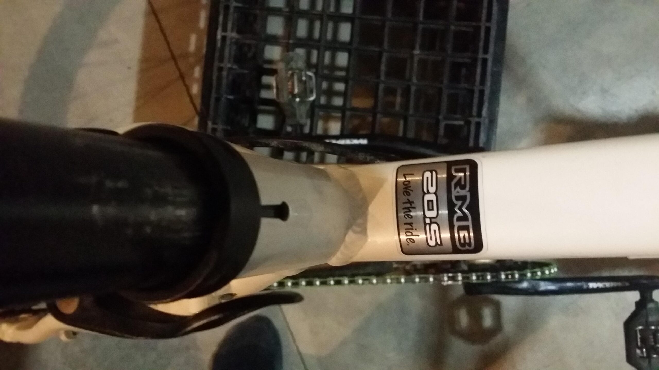 Rocky Mountain Vertex 990 rsl 2013: Close-up view of a bicycle frame featuring a "RMB 20.5" sticker with the text "Love the ride." The frame is white with some black components visible, and there's a chain in the background.