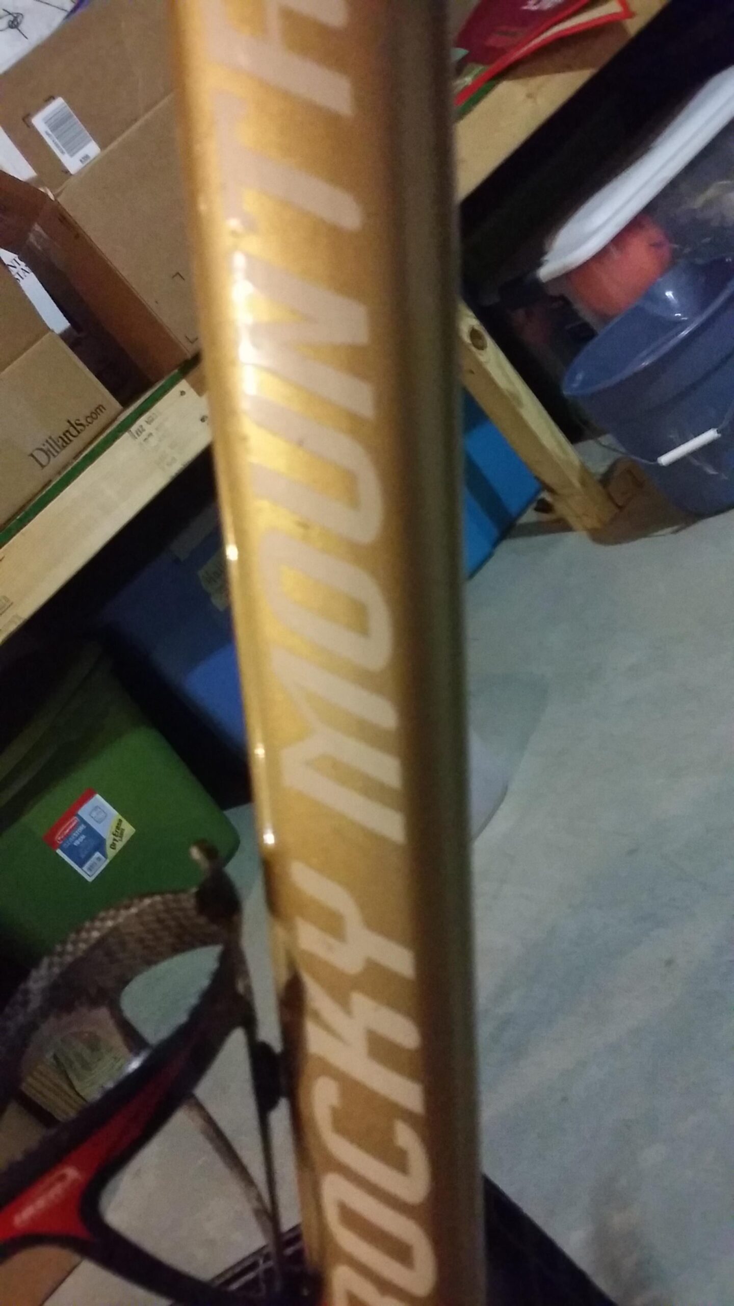 Rocky Mountain Vertex 990 rsl 2013: Close-up image of a Rocky Mountain bicycle frame in a dimly lit garage setting. A black and red water bottle holder is attached to the frame, with boxes and storage containers visible in the background.