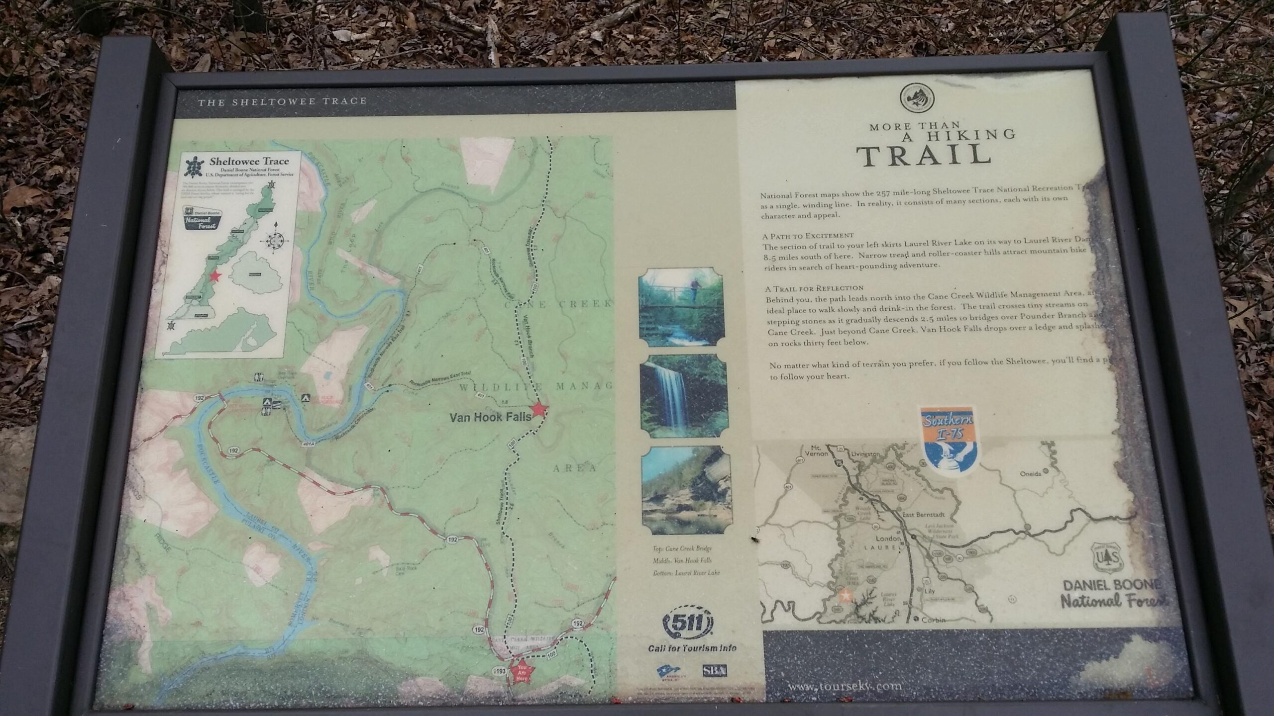 Sign showing a map and information about the Sheltowee Trace, a 257-mile trail in the Daniel Boone National Forest. The sign includes illustrations of landmarks such as Van Hook Falls and Cane Creek, along with descriptions of the trail's features, encouraging walking and reflection in nature. Sheltowee Trace - Laurel Lake Trail mountain bike trail.