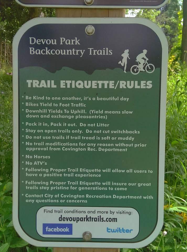 Sign detailing trail etiquette and rules for Devou Park Backcountry Trails, including guidelines for foot and bike traffic, littering, trail use, and contact information for the Covington Recreation Department. Devou Park mountain bike trail.