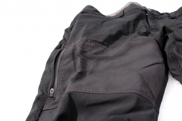 Black lightweight pants featuring a side zippered pocket, displayed on a white background. The fabric appears smooth with a subtle sheen.