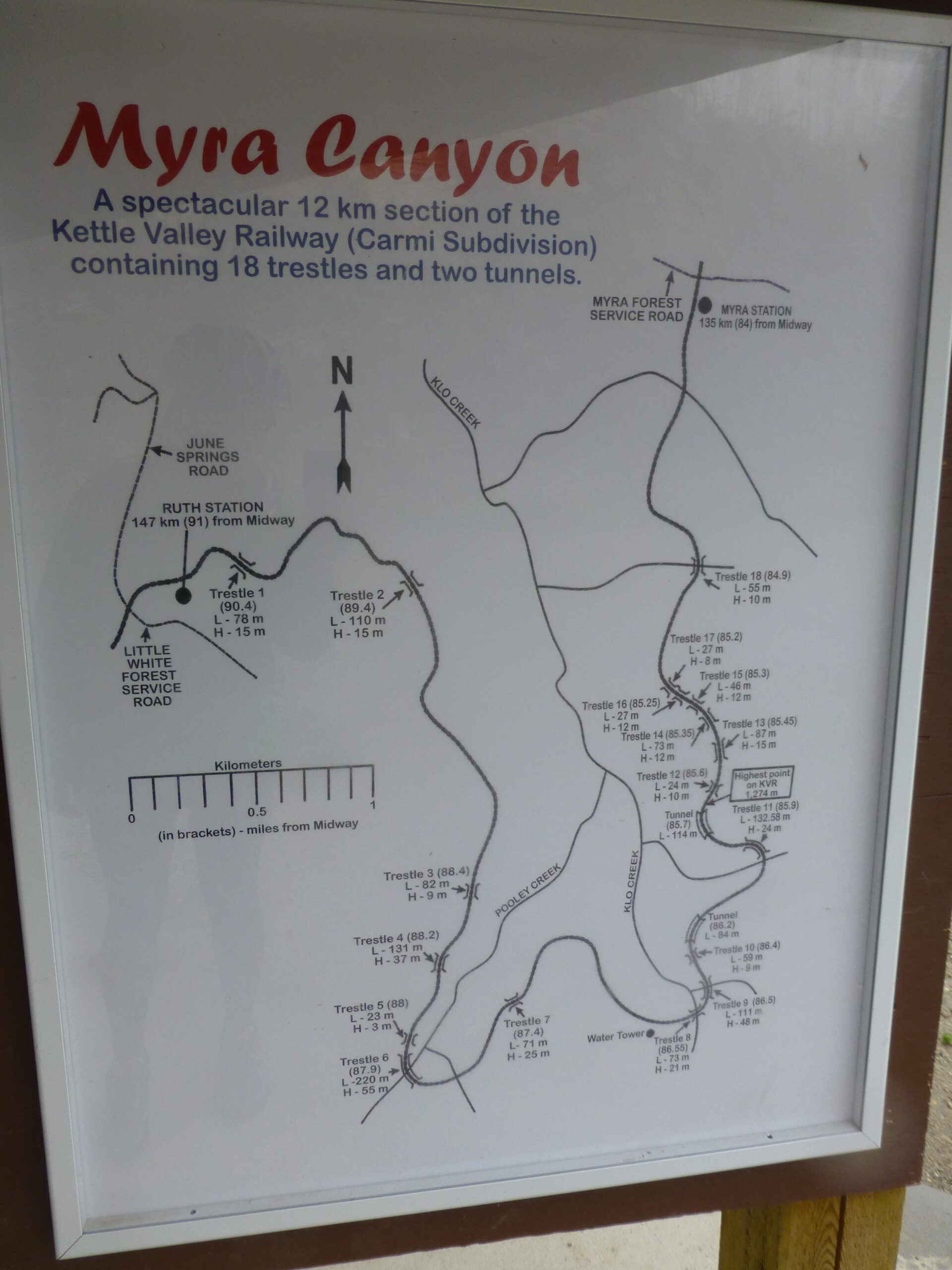 Map highlighting the Myra Canyon section of the Kettle Valley Railway, detailing a 12 km route that includes 18 trestles and two tunnels. Key features include labeled trestles with their lengths and heights, nearby roads, and geographic orientation with a north arrow. Kettle Valley Railway Trail (KVR) Myra Canyon to Penticton return mountain bike trail.