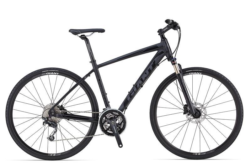 Giant Roam 0: A sleek black hybrid bicycle featuring a lightweight frame, front suspension, disc brakes, and multi-gear drivetrain. The bike includes thin tires designed for both road and light off-road cycling, showcasing its versatility and modern design.