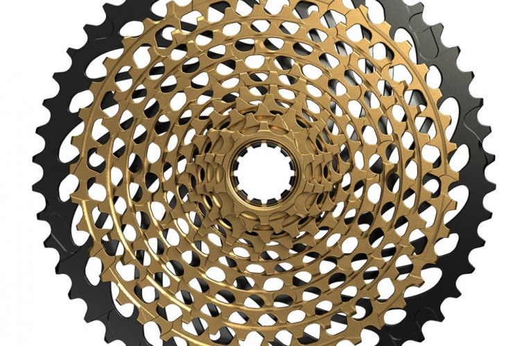 A circular bicycle cassette featuring a layered design with gold and black levels. The inner section is gold, with interspersed cutouts, while the outer layer is black with a toothed edge, showcasing a detailed and modern gear system for cycling.