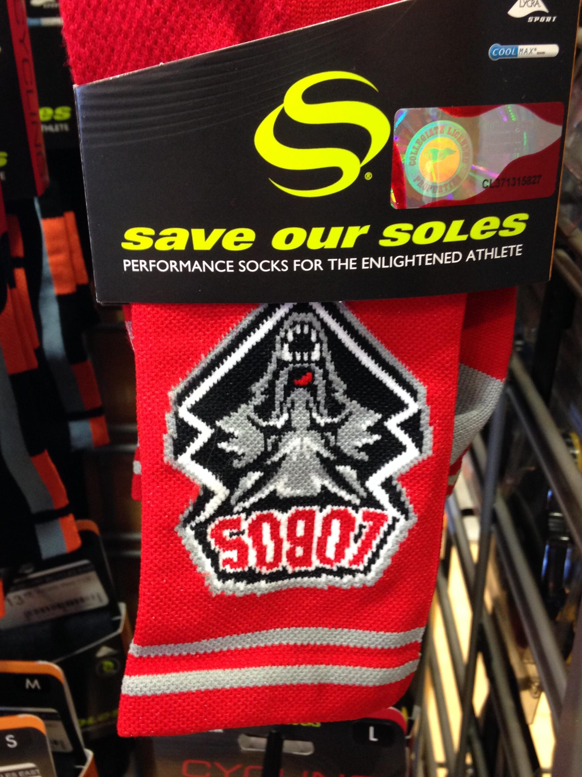 Red performance socks featuring a graphic design of a mountain and a stylized logo with the text "SOBOT." The packaging includes the phrase "save our soles" and highlights the product as suitable for athletes.