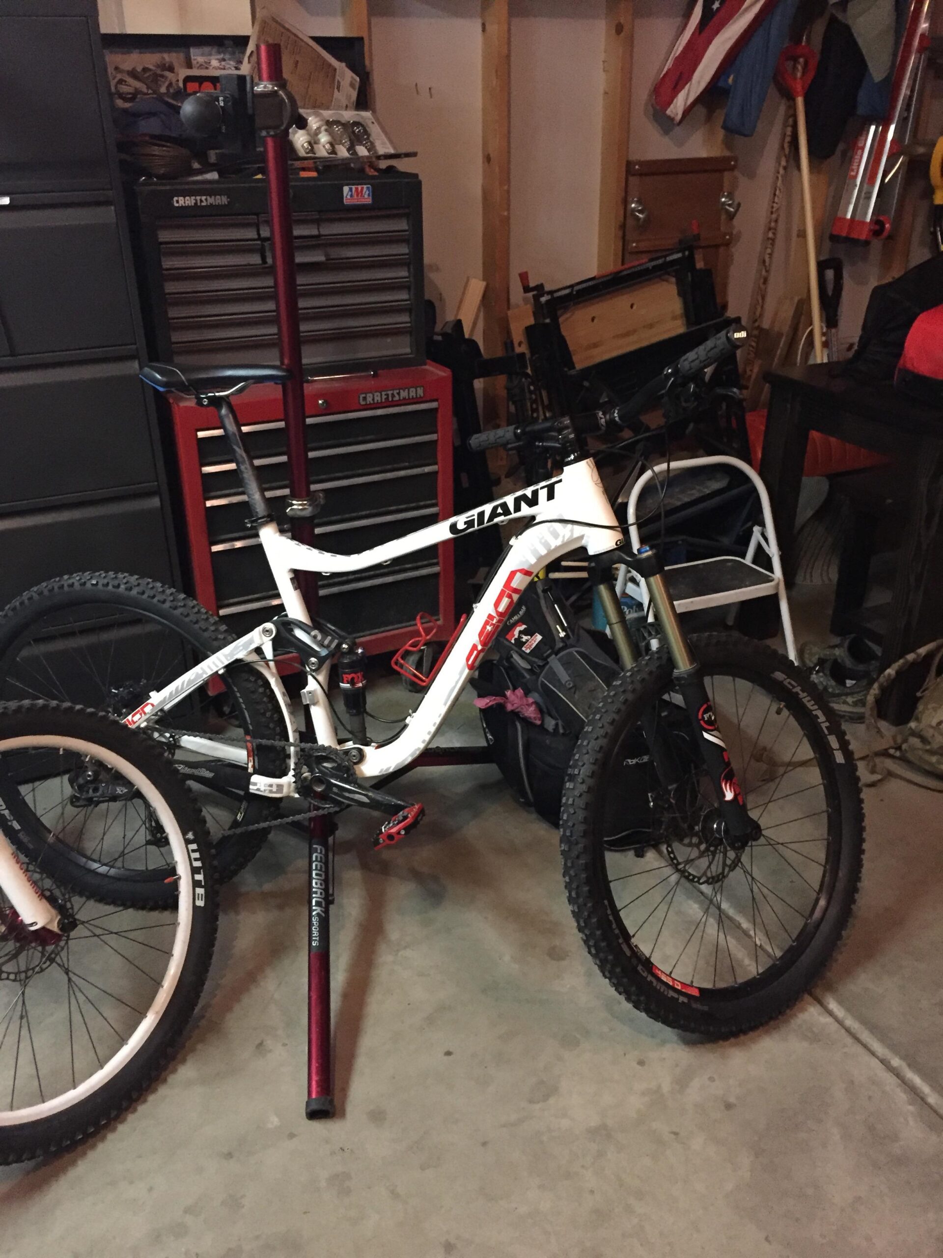 Giant Reign 2: A mountain bike leaning against a tool chest in a garage, with a visible dropper seat post and various tools and equipment in the background.