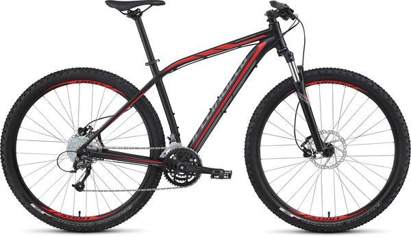Specialized Rockhopper Sport 29: Mountain bike with a black frame and red accents, featuring wide tires, a front suspension fork, and a multi-gear system.