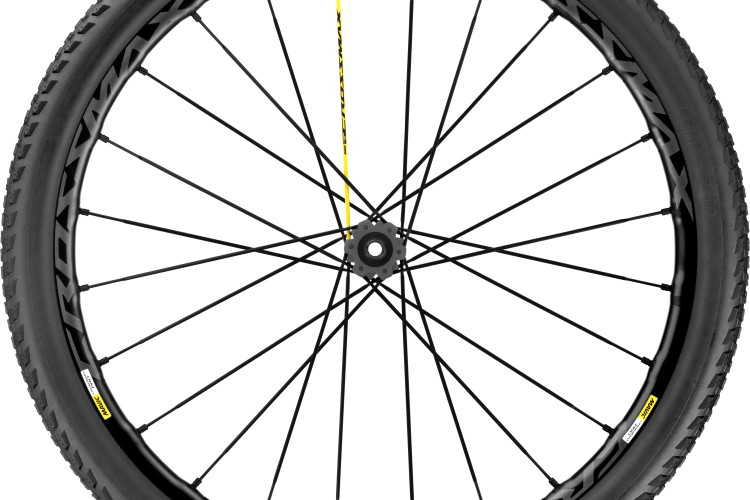 A high-quality mountain bike wheel featuring a black rim and tire. The rim displays the Mavic logo and is designed for durability, with multiple spokes radiating from the central hub. The tire has an aggressive tread pattern suited for off-road terrain.