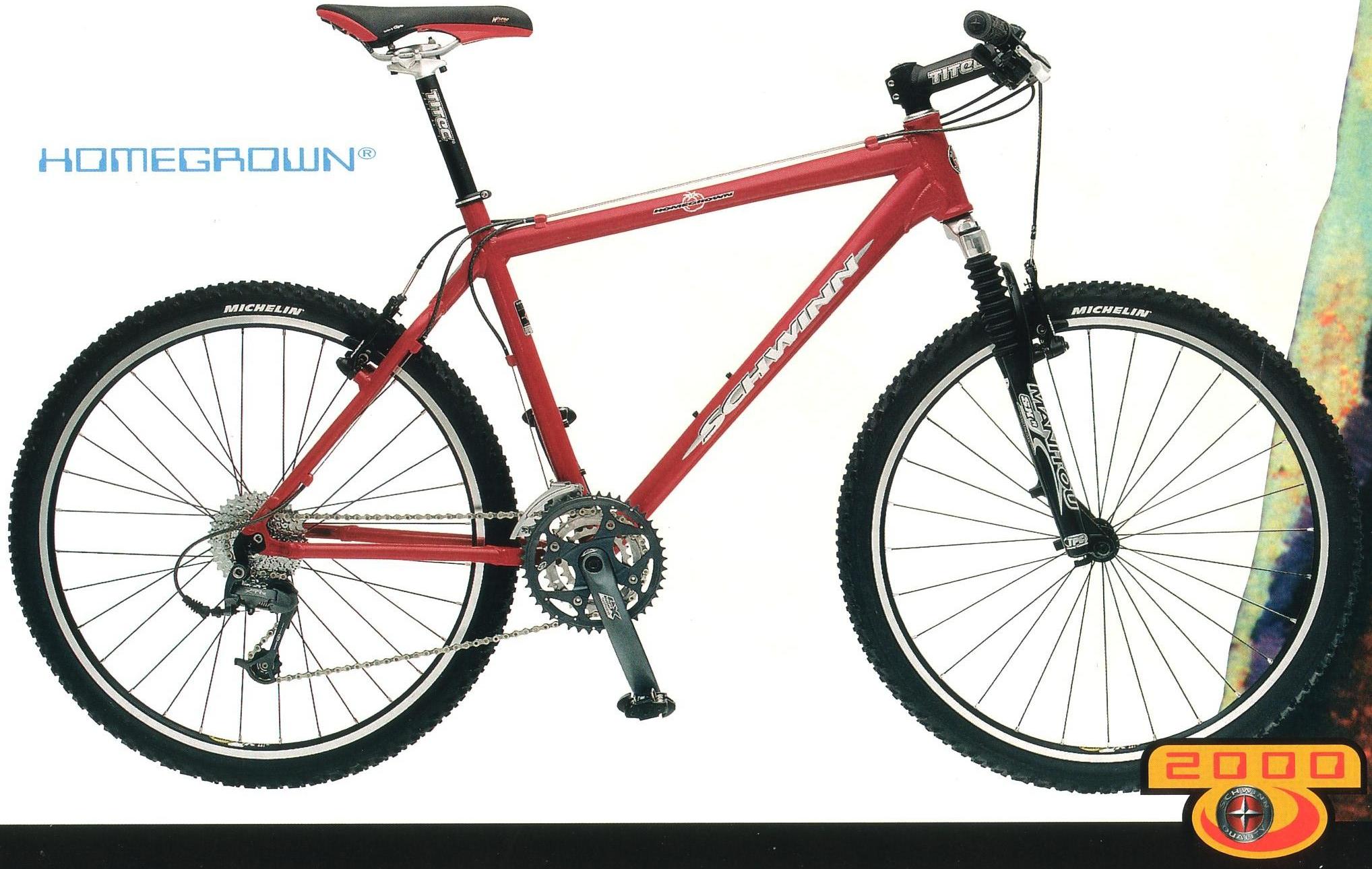 Schwinn Homegrown: A red Schwinn mountain bike featuring a sturdy frame, front suspension, and rugged tires. The bike is displayed against a white background with the logo "HOMEGROWN" prominently shown. The design reflects a classic mountain biking aesthetic, showcasing details like the Shimano gear system and Michelin tires.