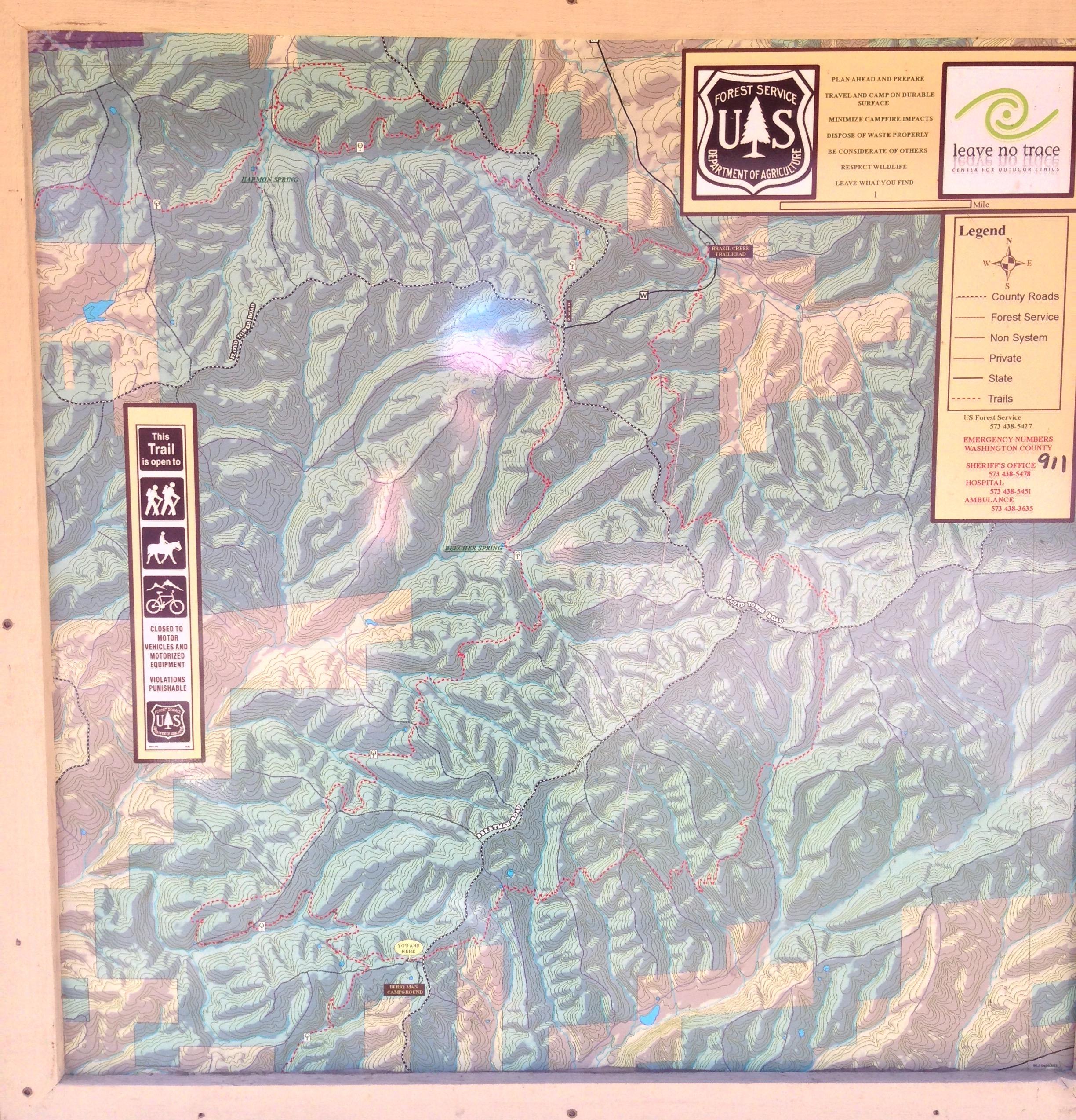A detailed topographic map displaying various hiking and biking trails, forest service roads, and terrain features. The map includes a legend indicating trail accessibility for pedestrians, horseback riders, and cyclists, along with emergency contact information and guidelines for responsible outdoor activities. The overall color scheme reflects the area's mountainous landscape. Berryman mountain bike trail.