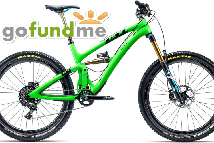 A vibrant green mountain bike with black tires and gold suspension components is displayed against a white background. The bike features a modern design, a dual suspension system, and branding for Maxxis tires. The GoFundMe logo is superimposed in the upper area of the image.
