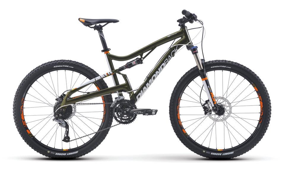 Diamondback Recoil Comp 29er: Mountain bike with a green frame and white branding, featuring wide tires, disc brakes, and a suspension system, positioned against a plain background.