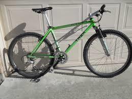 Trek 8000: A green mountain bike with a silver frame, front suspension, and knobby tires, leaning against a garage door.