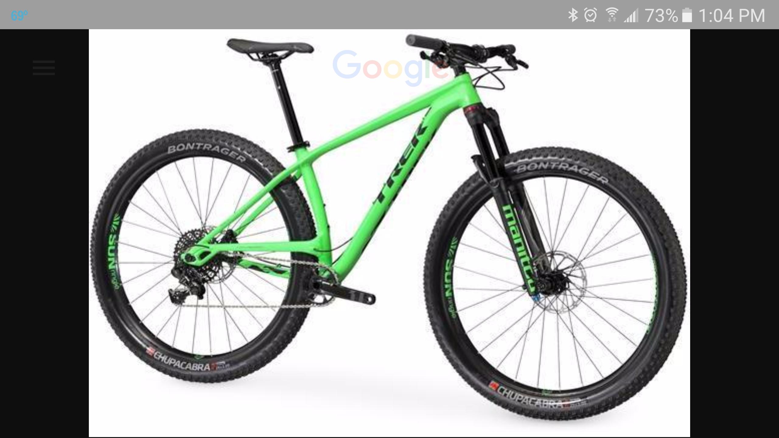 Trek Stache: Alt text: A bright green mountain bike with thick tires and a sleek design, featuring branding from Trek and Bontrager. The bike is positioned against a white background, highlighting its features, including a front suspension fork and a modern frame.