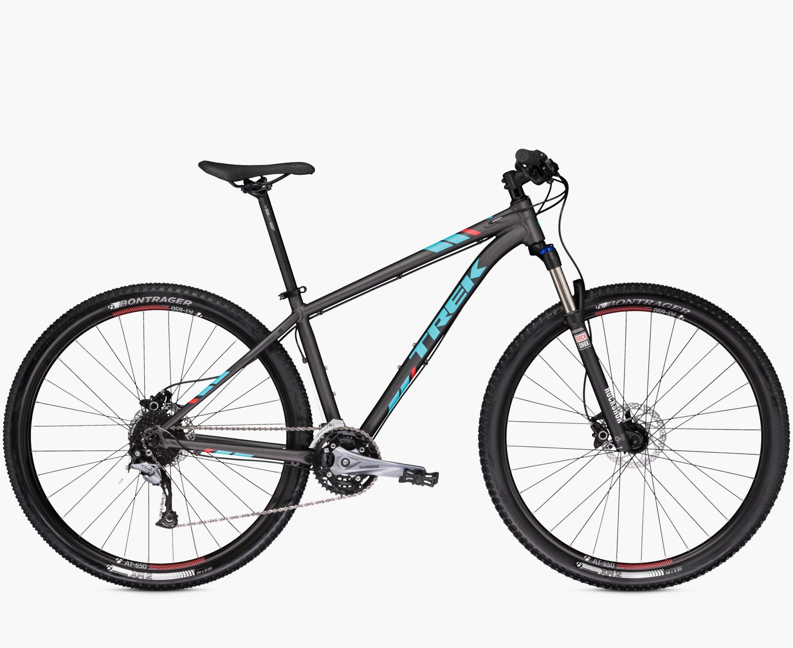 Trek X-Caliber 7: Mountain bike from Trek featuring a gray frame with turquoise and red accents. The bike is equipped with front suspension, Bontrager tires, and a Shimano gear system.
