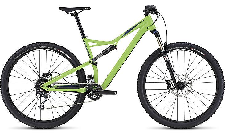 Specialized Camber 29: A green and black mountain bike with a lightweight frame, designed for off-road terrain. It features wide tires, a front suspension fork, and a modern gear setup, showcasing a sporty and sleek design.