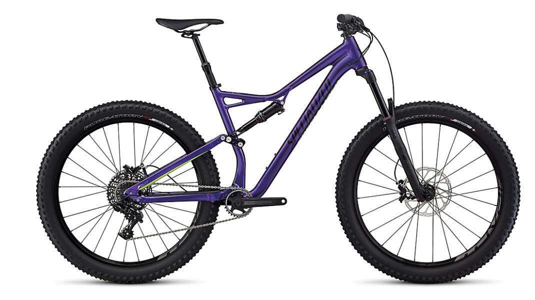 Specialized Stumpjumper FSR Comp 6Fattie: A sleek purple mountain bike with wide tires and a sturdy frame, featuring a suspension system and disc brakes, positioned against a plain background.