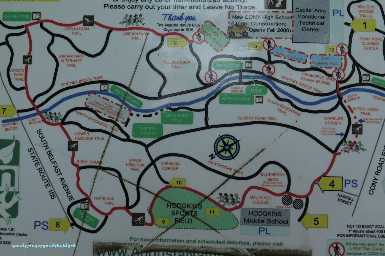 Map of a nature trail area featuring various trails such as Jordan Farm Trail, Whitney Brook Trail, and more, along with landmarks like the Amphitheater and Dead Man's Cave. The map includes markers for educational institutions and parks, as well as a note about responsible outdoor activity. Augusta Nature Center Trails mountain bike trail.