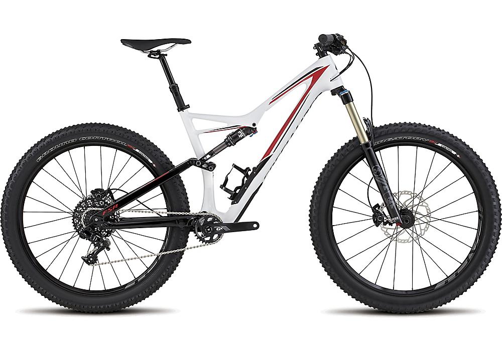 Specialized Stumpjumper FSR Comp 6Fattie: A modern mountain bike featuring a sleek white frame with red accents, wide tires, disc brakes, and a lightweight design. The bike is positioned at an angle to showcase its suspension and gear system, ideal for off-road trails and rugged terrain.