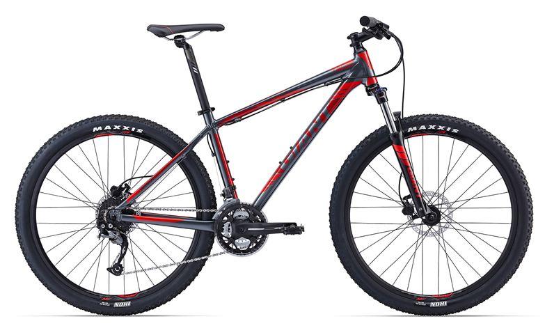 Giant 2016 Giant Talon 3: A sleek mountain bike featuring a gray and red frame, equipped with thick Maxxis tires and front disc brakes. The bike includes a standard handlebar and a gear system suitable for off-road terrain.
