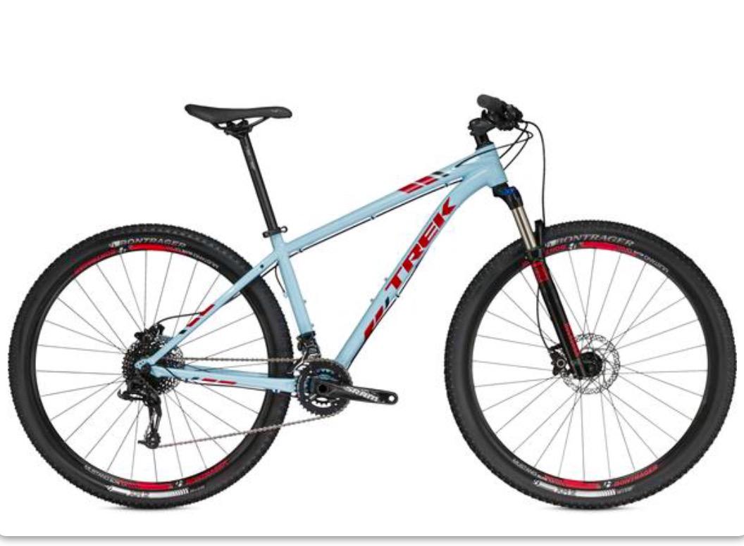 Trek X-Caliber 8: Light blue mountain bike with red accents, featuring a hardtail frame, front suspension, and disc brakes. The bike has wide tires designed for off-road terrain and is shown at a slight angle to highlight its frame and components.
