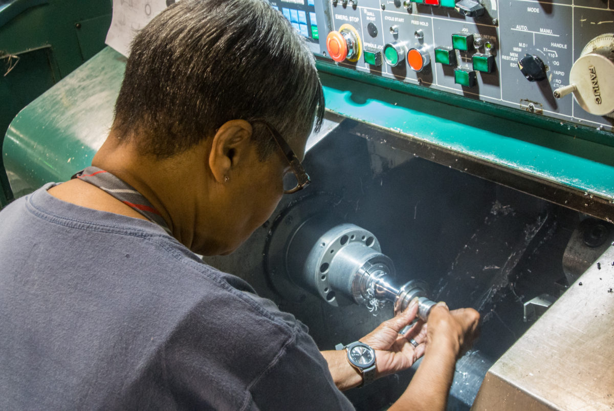 A machine operator removing a hub shell from the lathe (photo: Aaron Chamberlain)