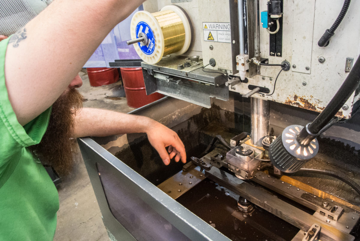 Setting up another EDM machine to cut pawls (photo: Aaron Chamberlain)