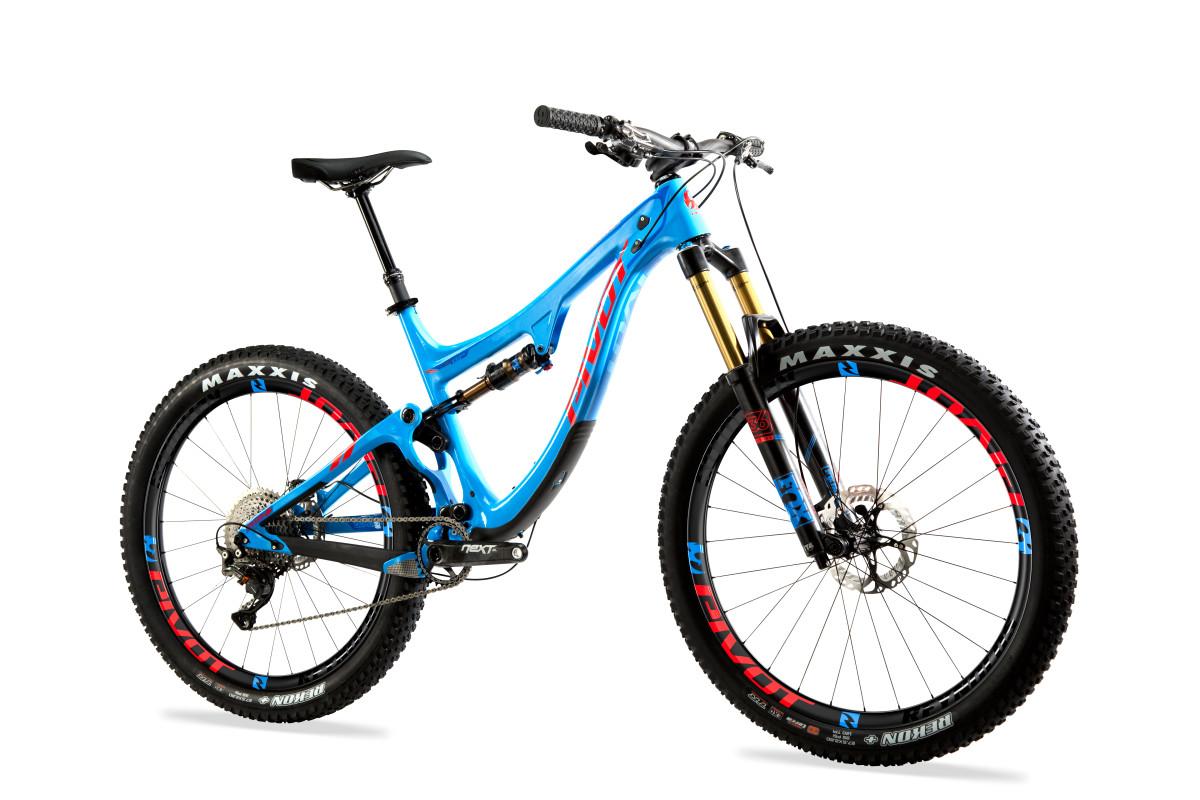 Pivot SwitchBlade: A blue mountain bike with a sleek frame and high-performance components, featuring Maxxis tires, a front suspension fork, and a modern design, set against a white background.