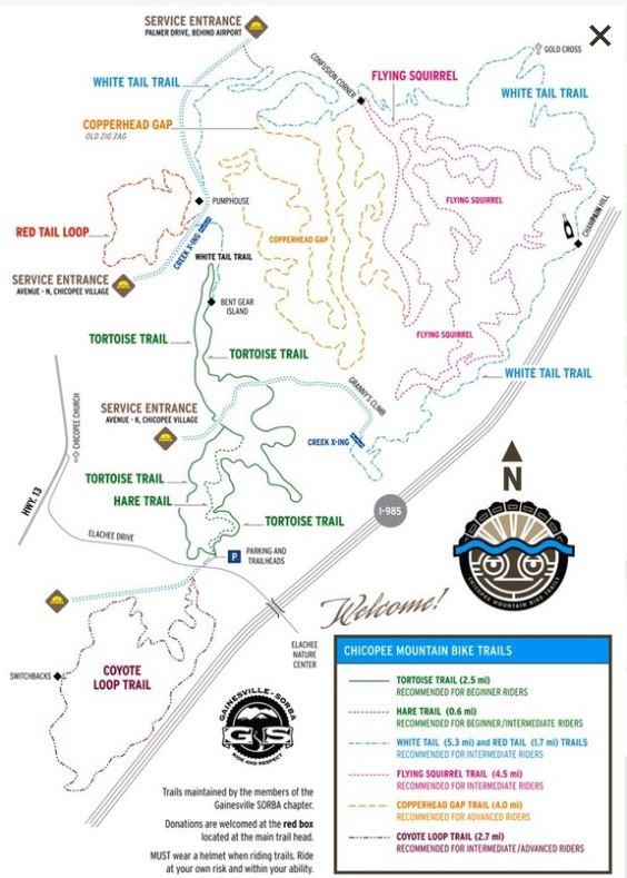 Map of the Chicopee Mountain Bike Trails, featuring various trails including Tortoise Trail, Hare Trail, White Tail Trail, and Flying Squirrel. The map indicates trail lengths and difficulty levels, with color-coded routes demonstrating different paths for beginner to advanced riders. Service entrances and key landmarks, like parking and rest areas, are also marked. A north arrow is included for orientation. Chicopee Woods mountain bike trail.