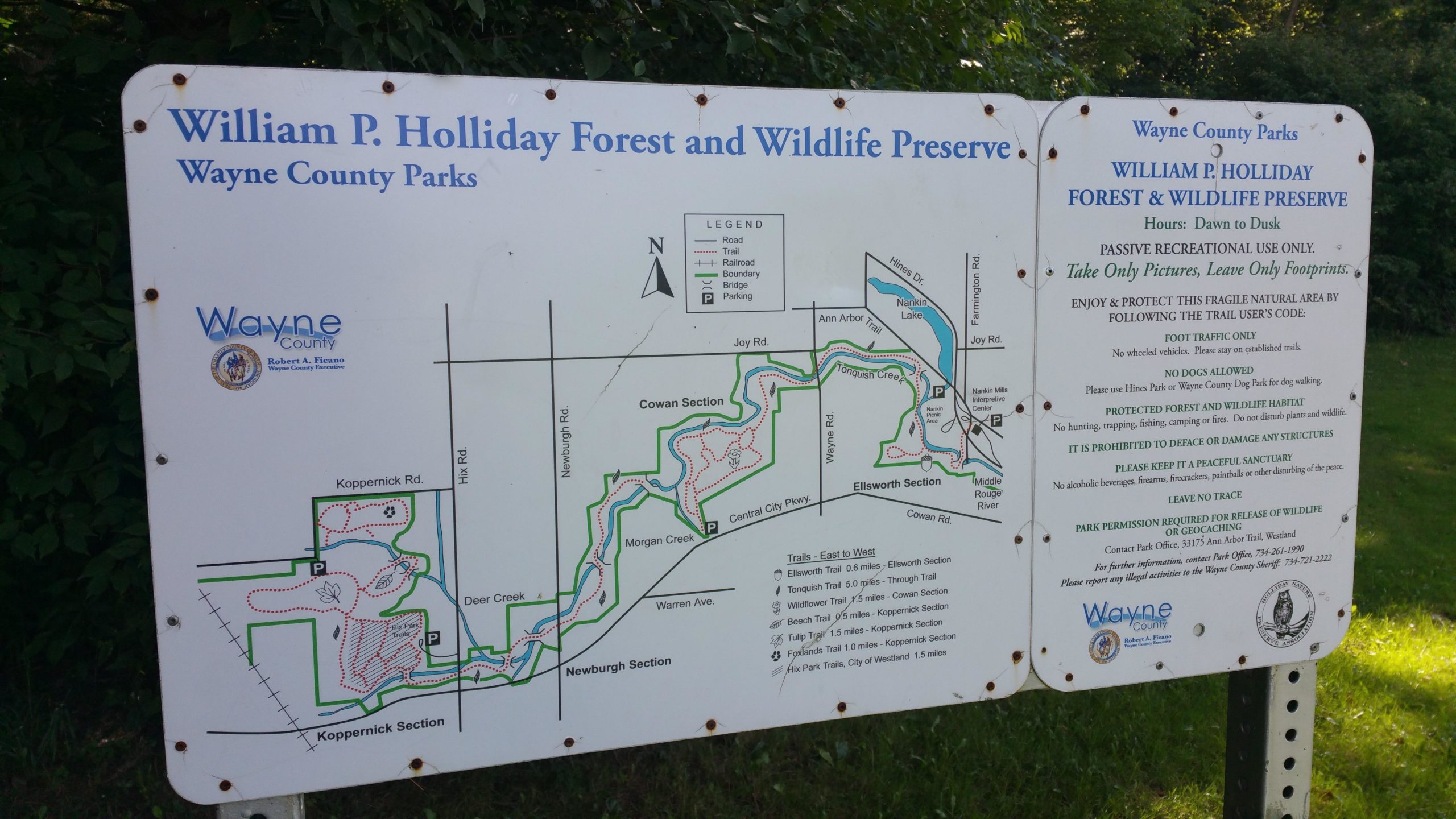 Signboard for William P. Holliday Forest and Wildlife Preserve in Wayne County, featuring a map of the park's trails and rules for visitors, including hours of operation, recreational guidelines, and conservation reminders. William P. Holliday Forest and Wildlife Preserve mountain bike trail.